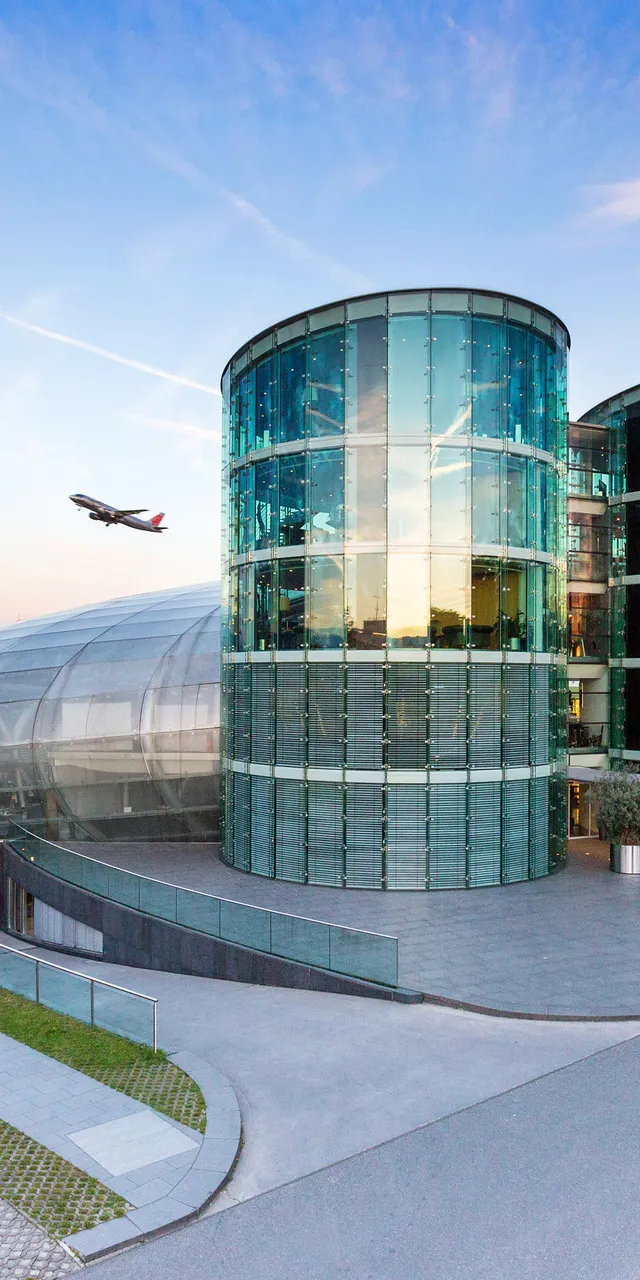 Außenaufnahme des Hangar-7 mit Flugzeug am Himmel