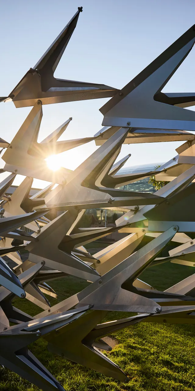 Metal sculpture in front of the glass architecture of Hangar-7