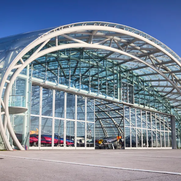 Exterior view of Hangar-7 with open gate, revealing exhibits inside the exhibition area