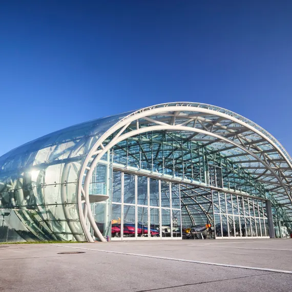 Exterior view of Hangar-7 with open gate, revealing exhibits inside the exhibition area