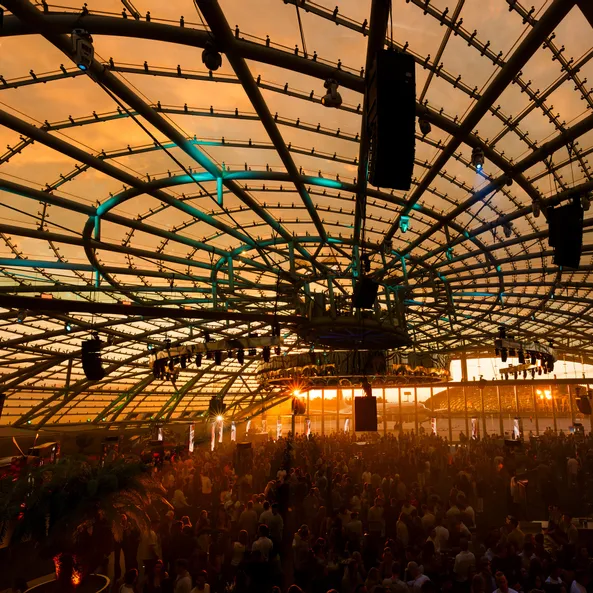 The Sunset event in the Red Bull Hangar-7 at sunset, bathing the entire hall and the crowd in golden light.