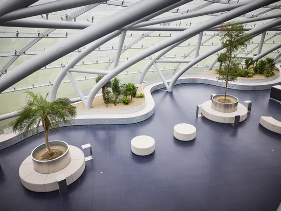 Innenansicht des Hangar-7 mit Glas-Stahl-Architektur, Sitzgelegenheiten und Pflanzen 