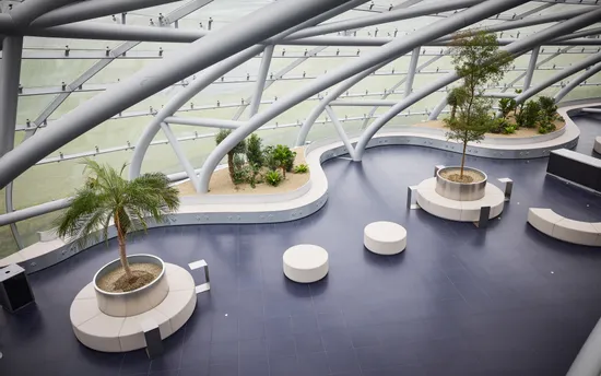Innenansicht des Hangar-7 mit Glas-Stahl-Architektur, Sitzgelegenheiten und Pflanzen 