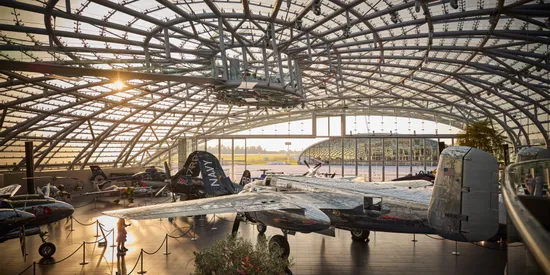 Innenansicht des Hangar-7 bei Sonnenuntergang mit Glasarchitektur und Ausstellungsexponaten
