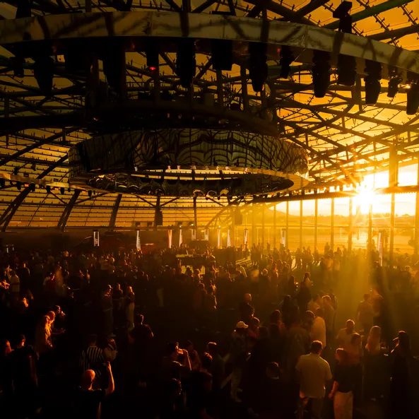 The Sunset event in the Red Bull Hangar-7 at sunset, bathing the entire hall and the crowd in golden light.