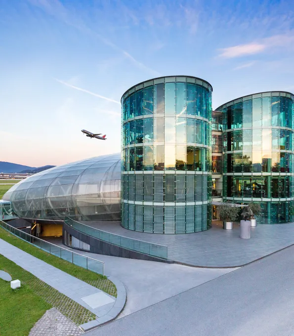 Außenaufnahme des Hangar-7 mit Flugzeug am Himmel