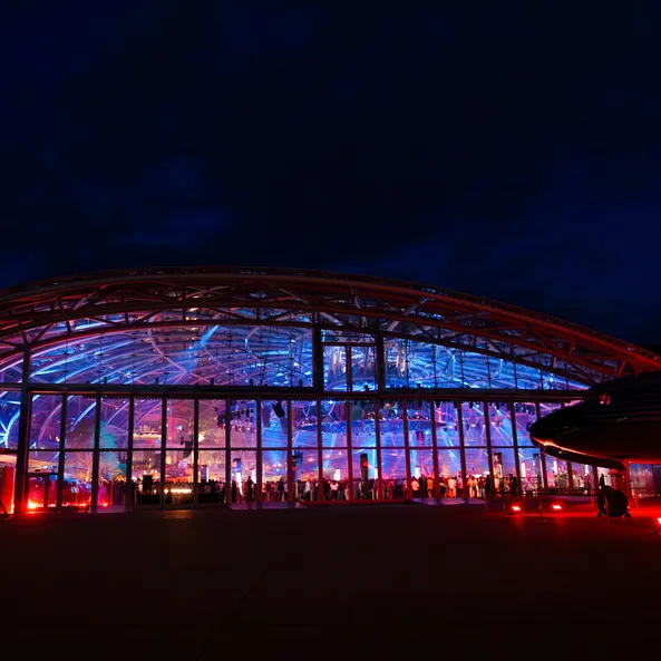 Exterior view of the illuminated Red Bull Hangar-7 at night during the Sunset event.