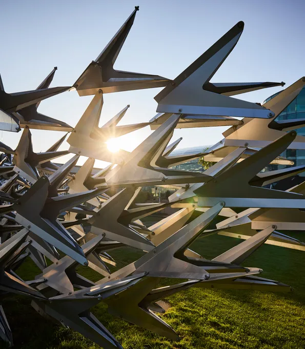 Metal sculpture in front of the glass architecture of Hangar-7