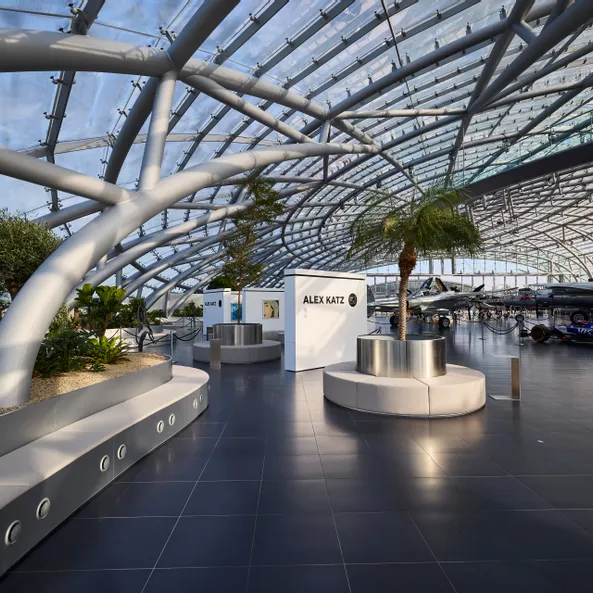 Interior view of Hangar-7 showing its glass-and-steel architecture, contemporary seating arrangements and an art exhibition 